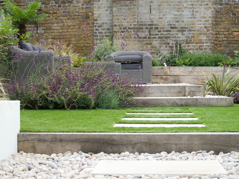 Low maintenance garden design with wild flowers and a seating area in Surrey